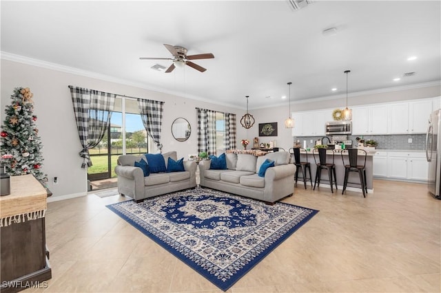 living room with ceiling fan and crown molding