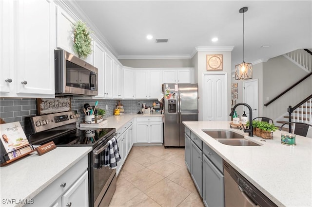 kitchen featuring white cabinetry, sink, tasteful backsplash, appliances with stainless steel finishes, and ornamental molding