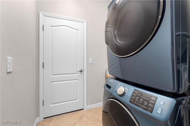 washroom featuring light tile patterned floors and stacked washer and clothes dryer