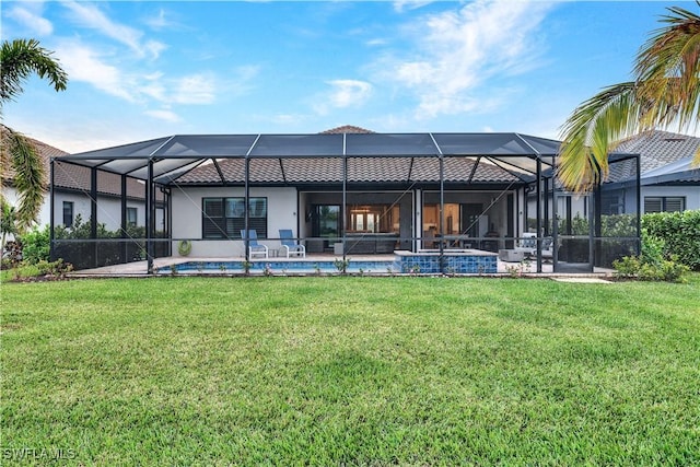 back of property featuring a lanai and a lawn