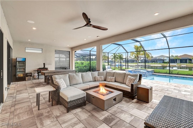 view of patio featuring a lanai, an outdoor living space with a fire pit, and an in ground hot tub