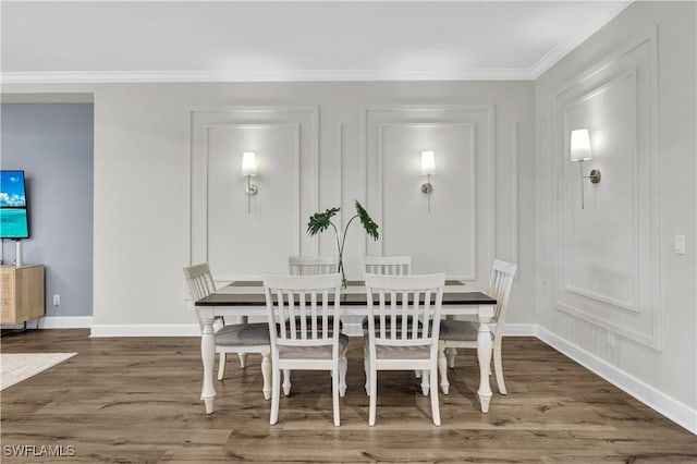 dining space with dark hardwood / wood-style flooring and ornamental molding