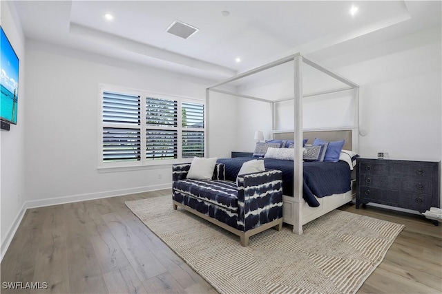 bedroom featuring a raised ceiling and hardwood / wood-style floors