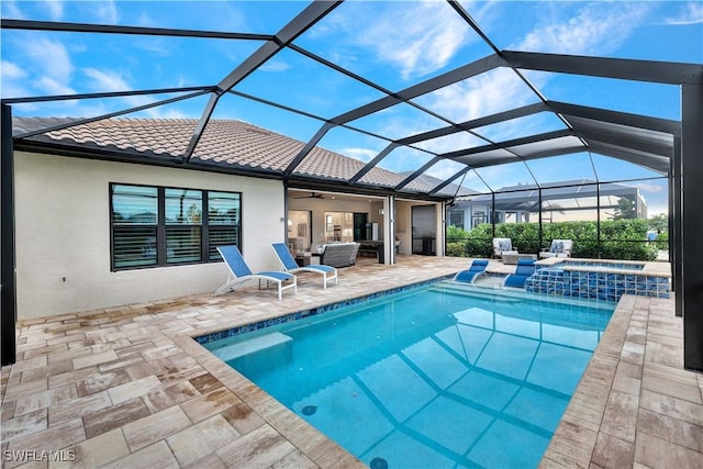 view of pool with a lanai, an outdoor hangout area, a patio, and an in ground hot tub