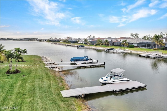 view of dock with a lawn and a water view