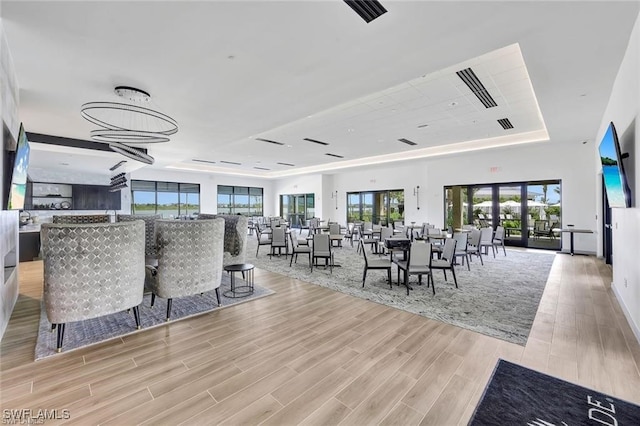 dining area with plenty of natural light and a tray ceiling