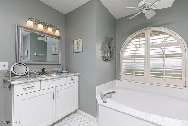 bathroom with a tub to relax in, vanity, and ceiling fan