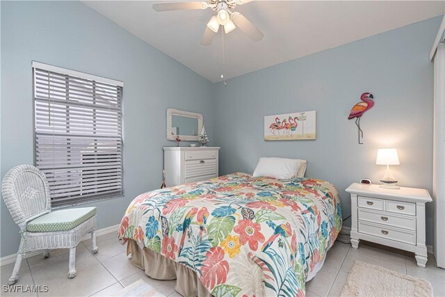 bedroom featuring ceiling fan, light tile patterned floors, and lofted ceiling