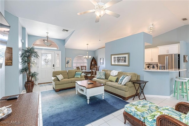 tiled living room with lofted ceiling and ceiling fan with notable chandelier