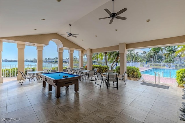 view of patio featuring ceiling fan, a fenced in pool, and a water view