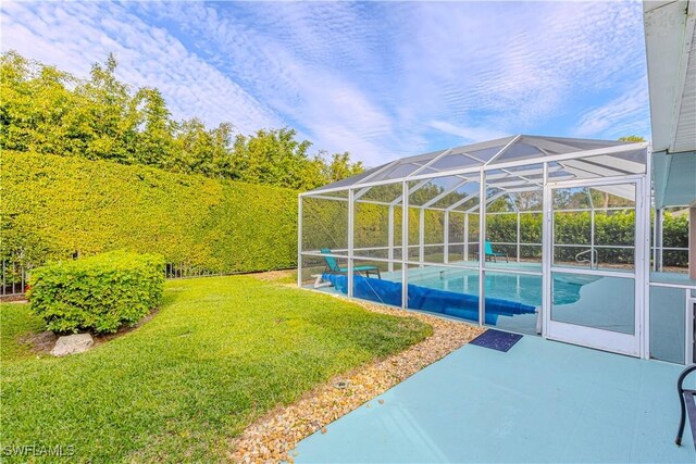 view of swimming pool with a lanai, a yard, and a patio