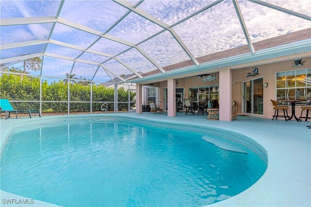 view of swimming pool featuring a lanai, ceiling fan, and a patio