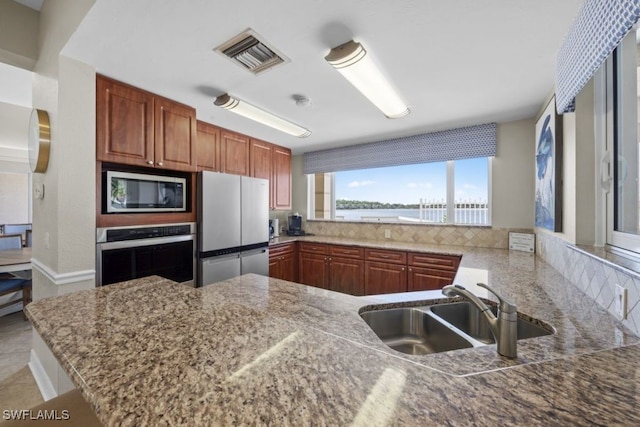 kitchen featuring stainless steel appliances, kitchen peninsula, and sink