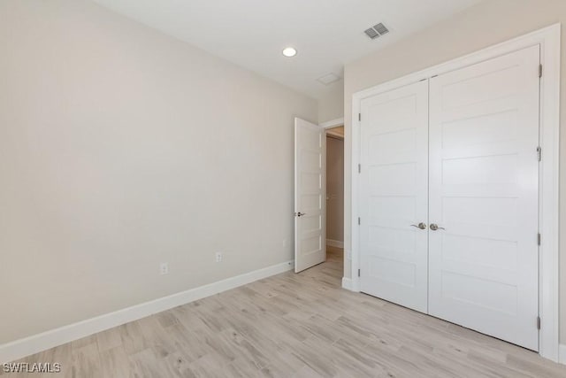 unfurnished bedroom with light hardwood / wood-style floors and a closet