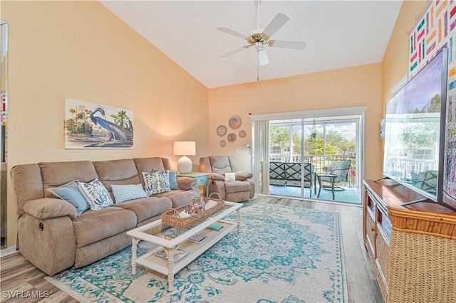 living room with hardwood / wood-style floors, high vaulted ceiling, and ceiling fan