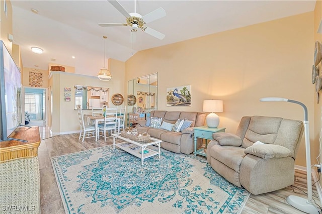 living room featuring wood-type flooring, vaulted ceiling, and ceiling fan