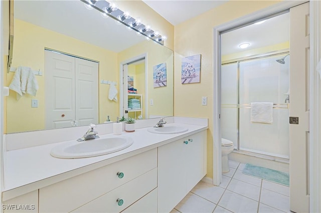 bathroom with tile patterned flooring, vanity, toilet, and a shower with shower door