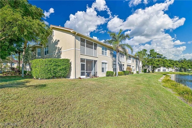 rear view of property featuring a yard and a water view