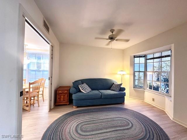 sitting room with light hardwood / wood-style floors and ceiling fan