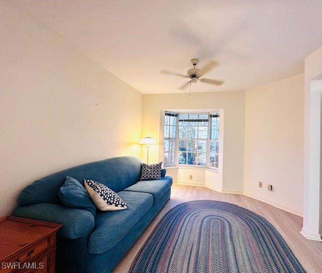 living room with ceiling fan and light hardwood / wood-style flooring