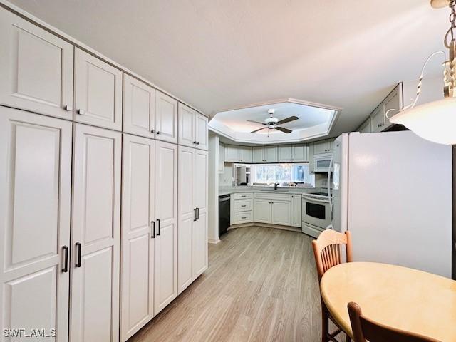 kitchen featuring white cabinetry, white appliances, light hardwood / wood-style floors, and ceiling fan