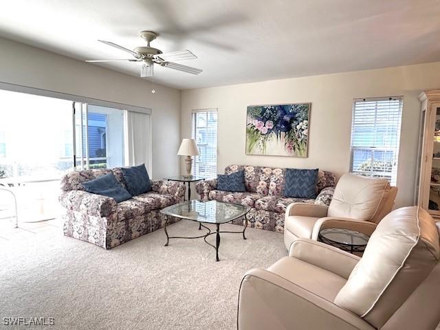 living room featuring ceiling fan and carpet