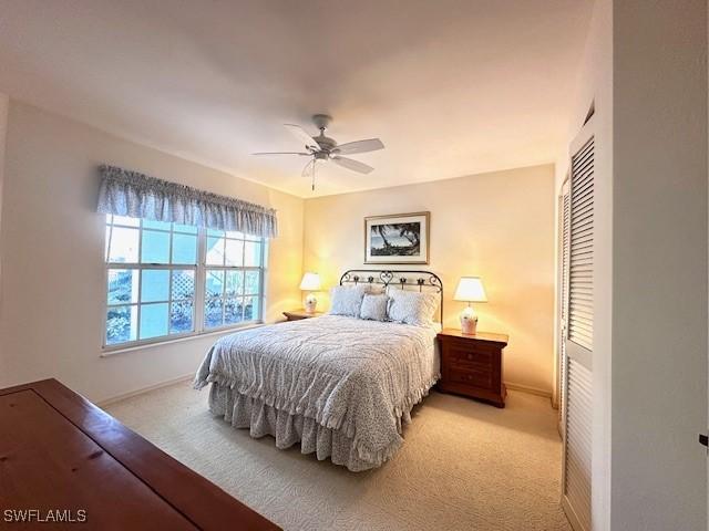 carpeted bedroom with ceiling fan and a closet