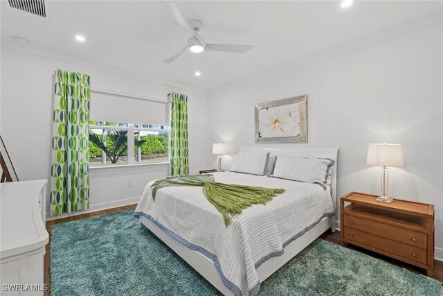 bedroom with hardwood / wood-style floors, ceiling fan, and ornamental molding