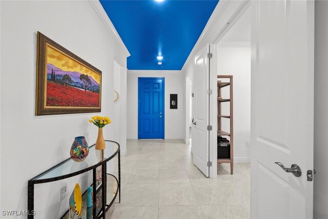 hall with crown molding and light tile patterned floors