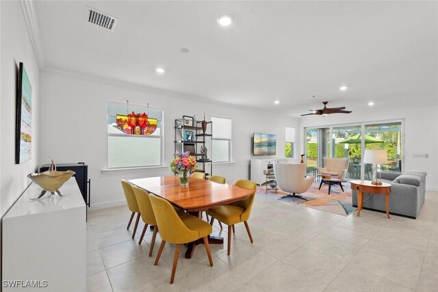 dining room with ceiling fan, crown molding, and light tile patterned flooring