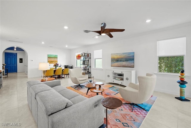 tiled living room featuring ceiling fan and crown molding