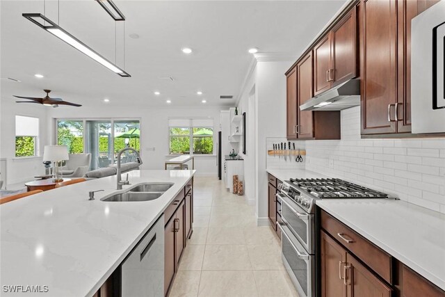 kitchen with appliances with stainless steel finishes, tasteful backsplash, ceiling fan, sink, and light tile patterned floors