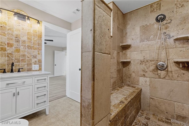 bathroom featuring ceiling fan, vanity, and tiled shower