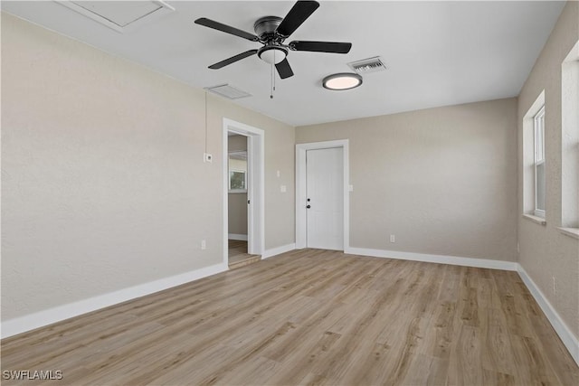 empty room with ceiling fan and light hardwood / wood-style flooring