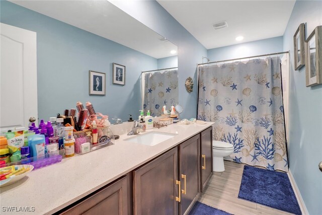 bathroom featuring a shower with curtain, vanity, toilet, and hardwood / wood-style flooring