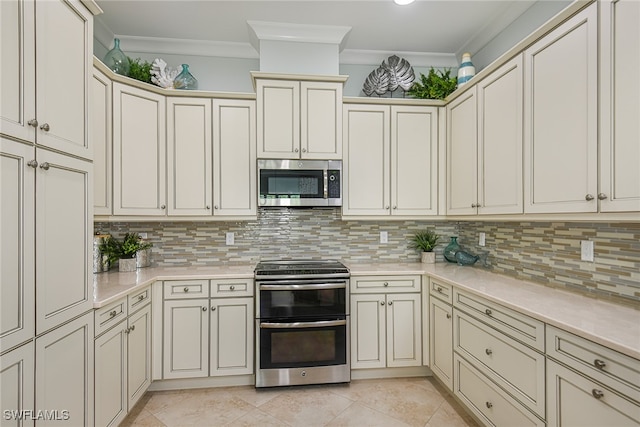 kitchen featuring cream cabinetry, backsplash, and appliances with stainless steel finishes