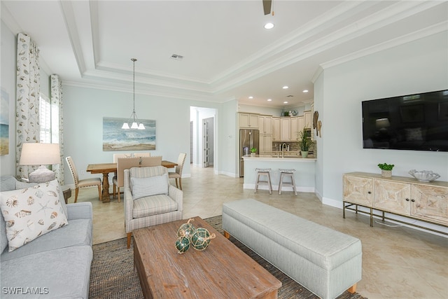 tiled living room featuring a raised ceiling, ornamental molding, and an inviting chandelier