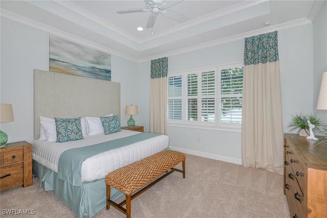 bedroom with ceiling fan, ornamental molding, light carpet, and a tray ceiling