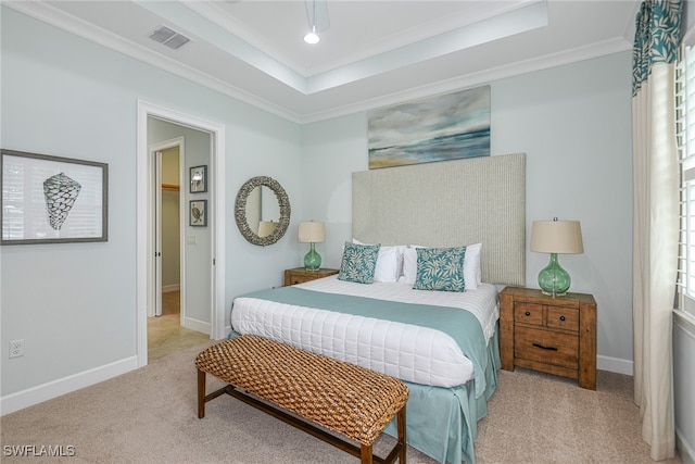 carpeted bedroom featuring a tray ceiling and crown molding