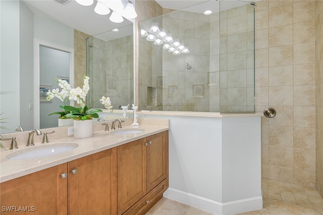 bathroom featuring tiled shower, vanity, and tile patterned floors