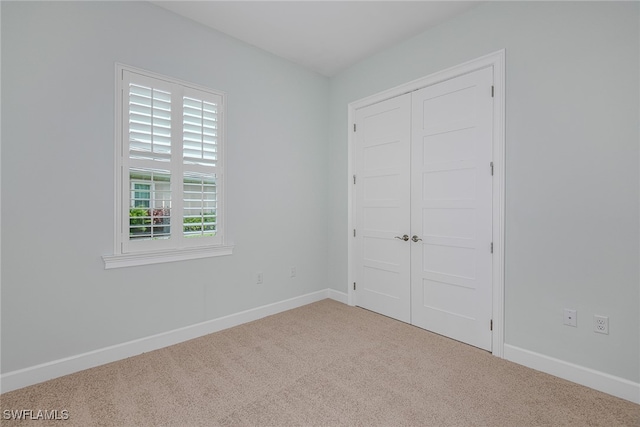 unfurnished bedroom featuring a closet, carpet floors, and multiple windows