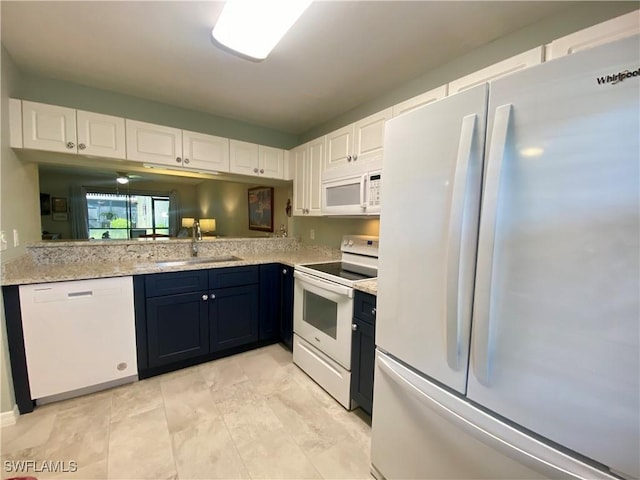 kitchen featuring white cabinetry, sink, light stone counters, and white appliances