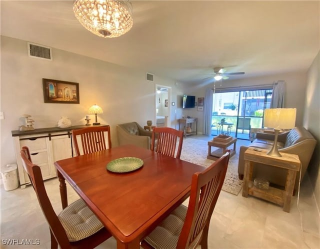 dining space with ceiling fan with notable chandelier