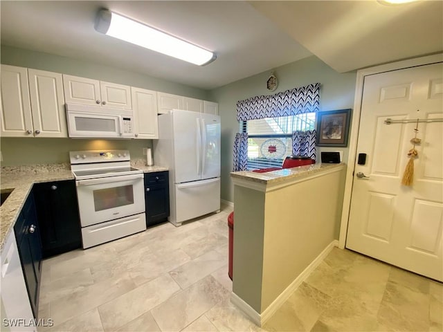 kitchen with white cabinetry, white appliances, and light stone countertops