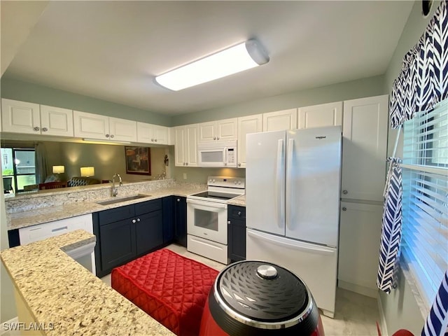 kitchen featuring white cabinetry, sink, light stone counters, and white appliances