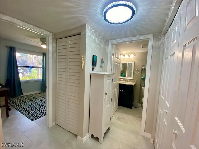 hall with sink and light tile patterned floors