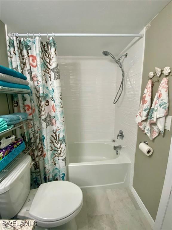 bathroom featuring shower / tub combo with curtain and toilet