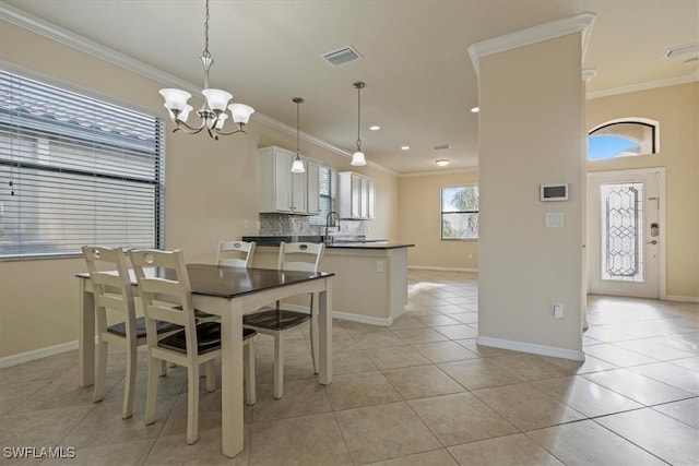 tiled dining area with an inviting chandelier, a wealth of natural light, and crown molding