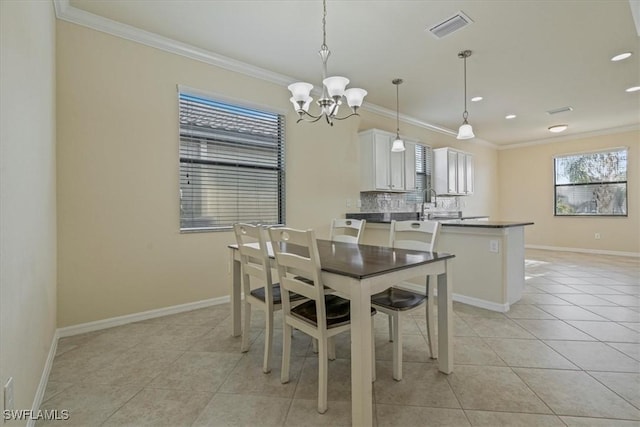 tiled dining area featuring sink, crown molding, and a notable chandelier