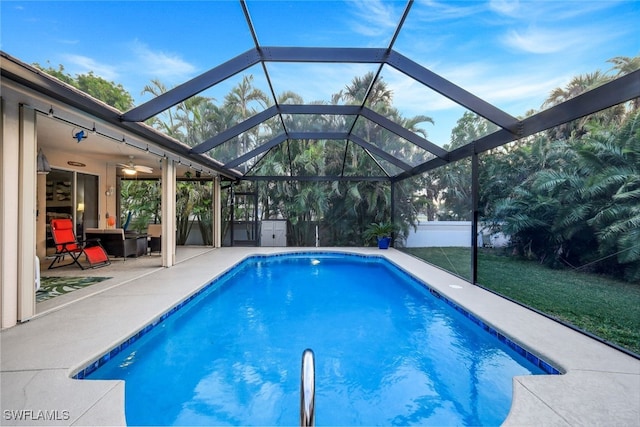 view of pool featuring a patio, ceiling fan, a lanai, and a lawn